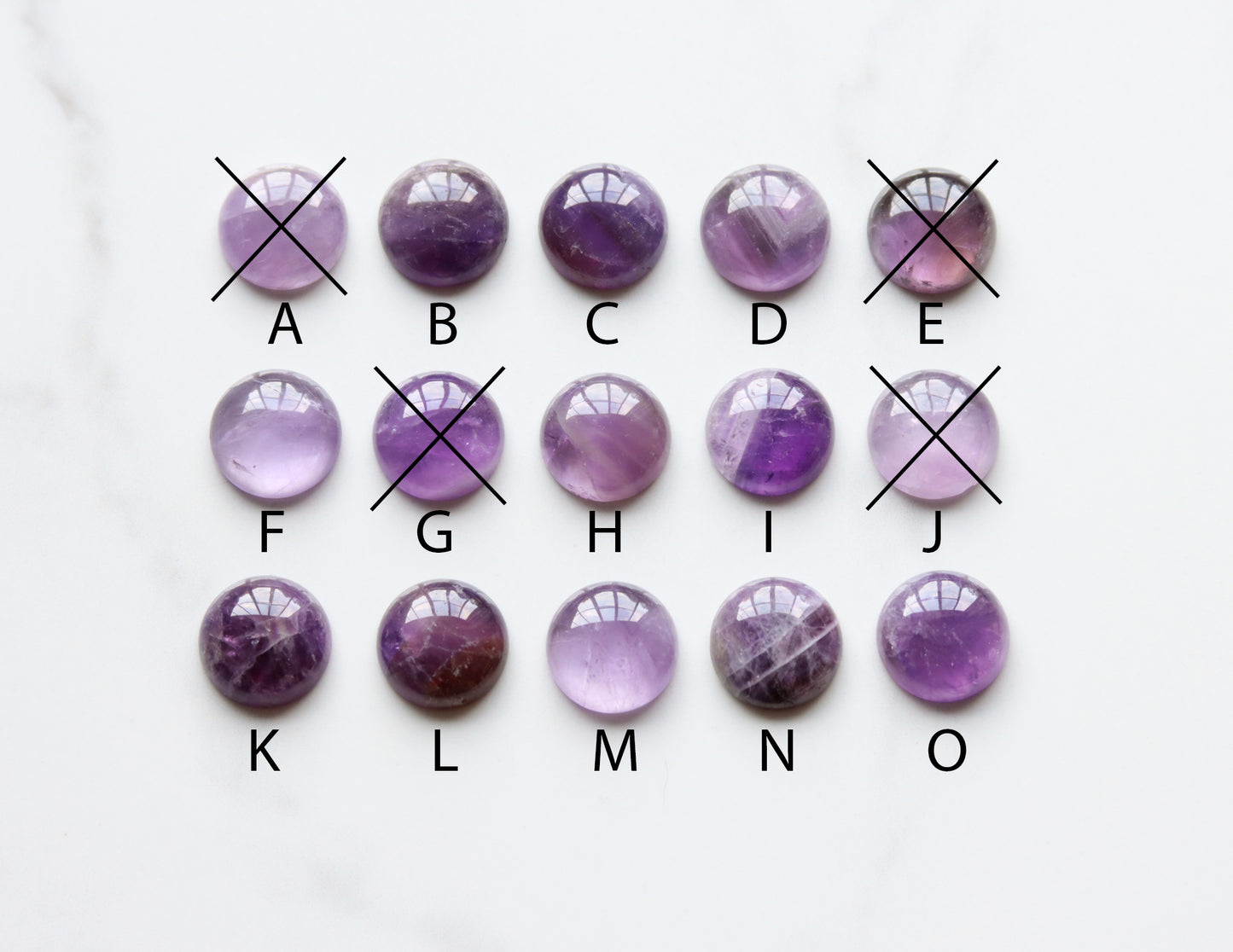 Purple amethyst gemstones arranged in a grid on a white background