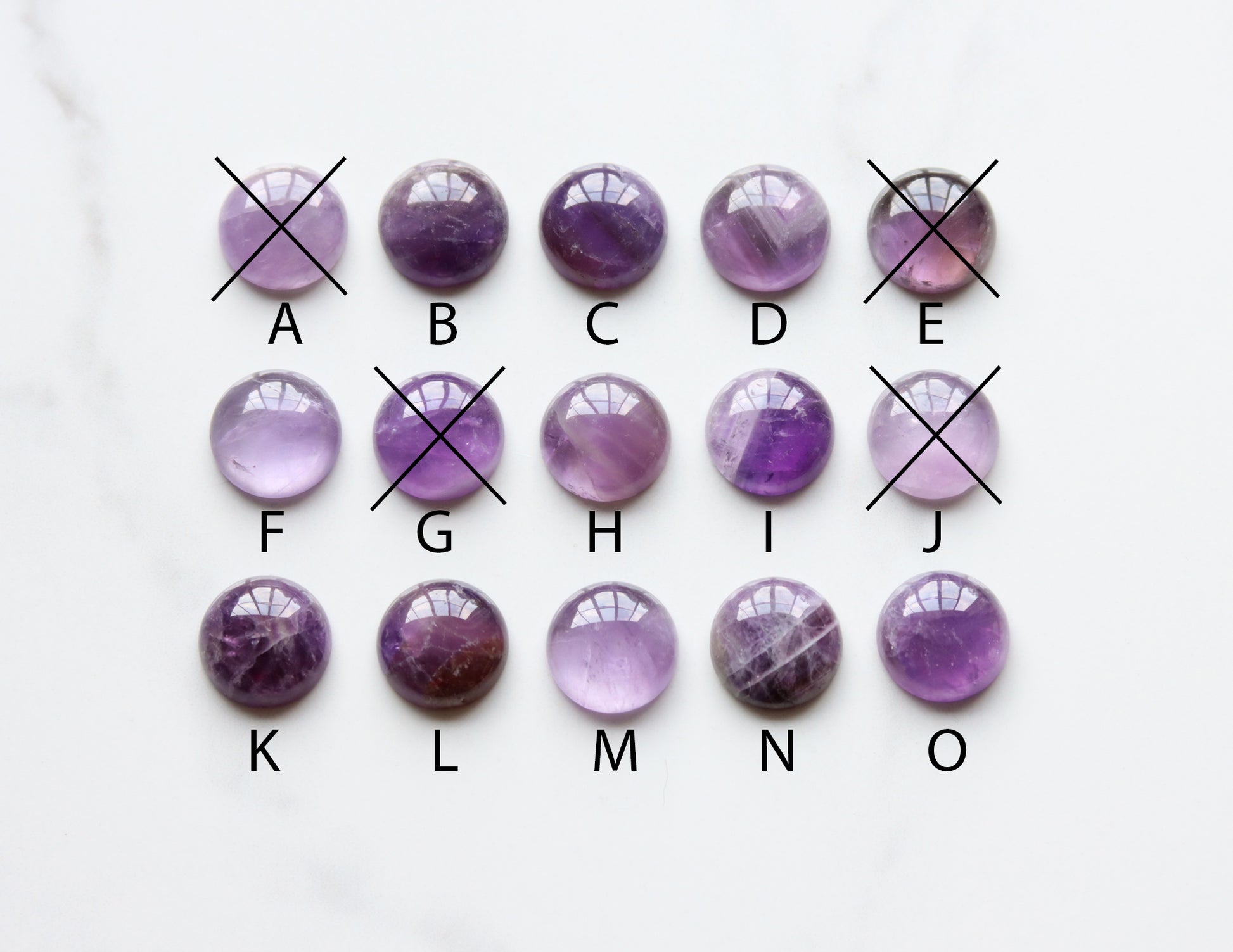 Purple amethyst gemstones arranged in a grid on a white background